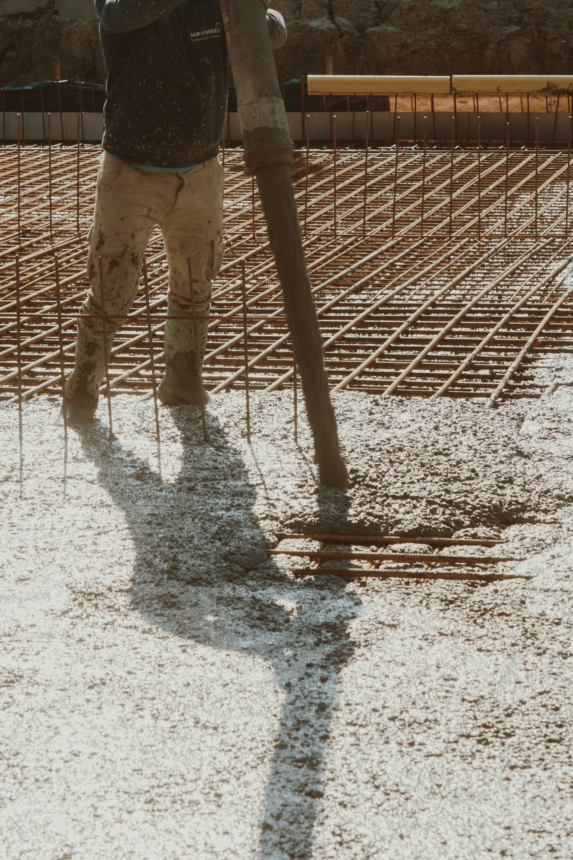 Concrete being placed over a rebar mesh grid for a slab